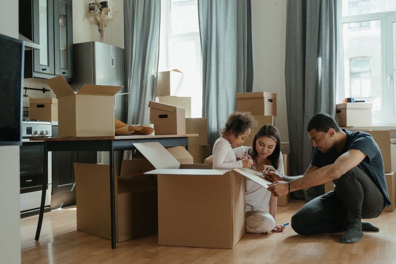Family unpacking moving boxes in a new home